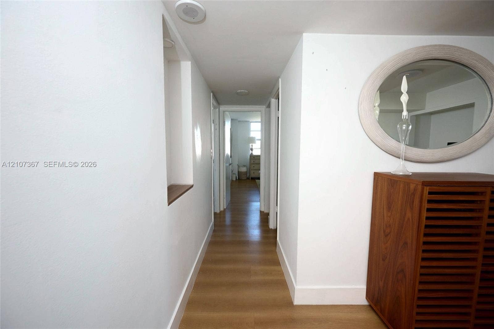 2851 NE 183rd Street, #1617E, Aventura, FL 33160 Hallway featuring wood-finish flooring, recessed ceiling lighting, and a built-in wall niche with a wooden shelf