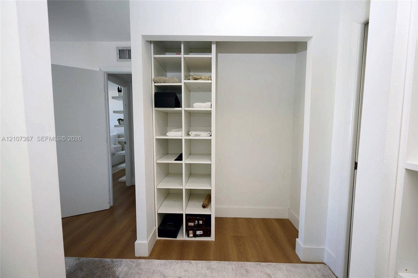 2851 NE 183rd Street, #1617E, Aventura, FL 33160 Built-in white shelving unit with multiple open storage compartments and wood-finish flooring