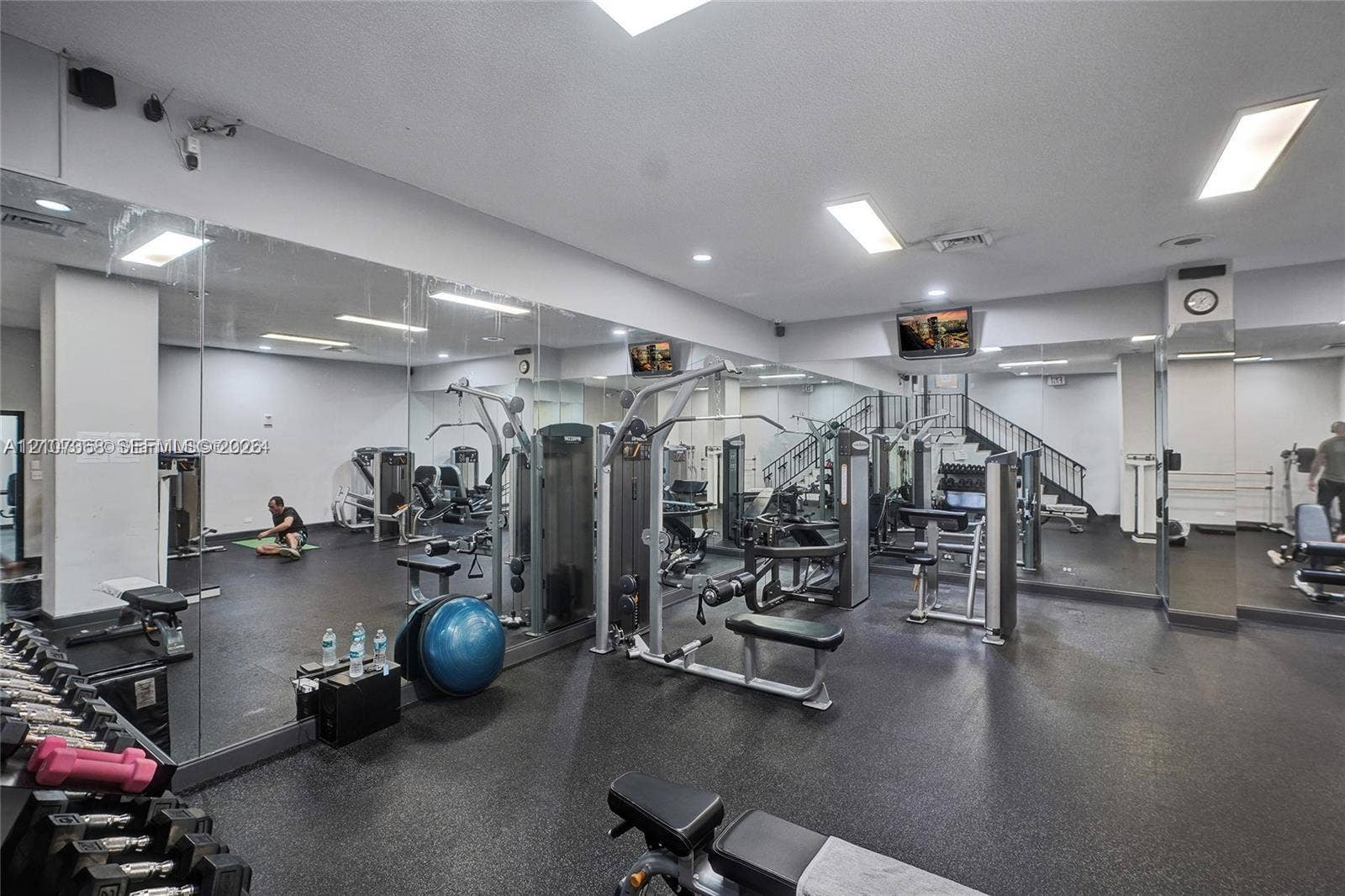 251 174th Street, #415, Sunny Isles Beach, FL 33160 Fitness center featuring rubber flooring, floor-to-ceiling wall mirrors, recessed lighting, and a staircase