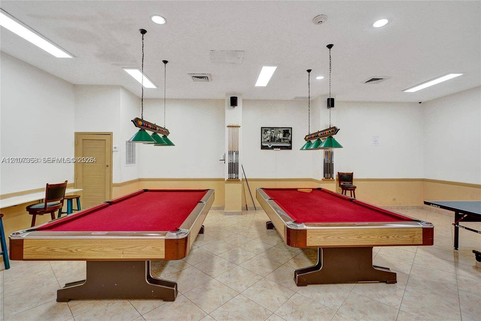 Recreational space featuring tile flooring, recessed lighting, and two built-in pendant light fixtures with green shades