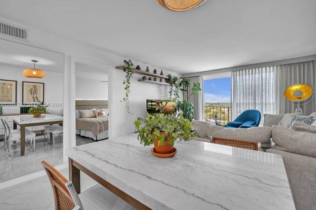 1800 N Andrews Avenue, #9K, Fort Lauderdale, Fort Lauderdale, FL 33311 Open-concept interior featuring large-format tile flooring, built-in wall shelving, expansive floor-to-ceiling glass sliding doors, and a full-wall mirror