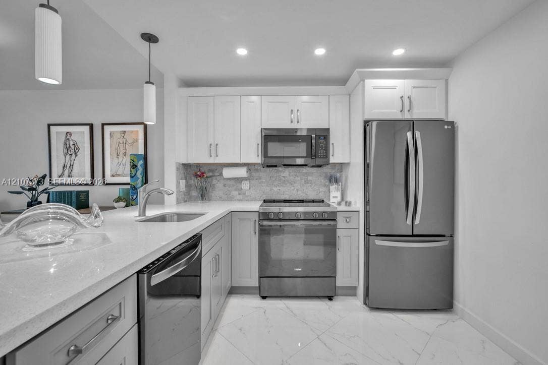 1800 N Andrews Avenue, #9K, Fort Lauderdale, Fort Lauderdale, FL 33311 Kitchen featuring white cabinetry, solid-surface countertops, stone tile backsplash, stainless steel appliances, and large-format tile flooring