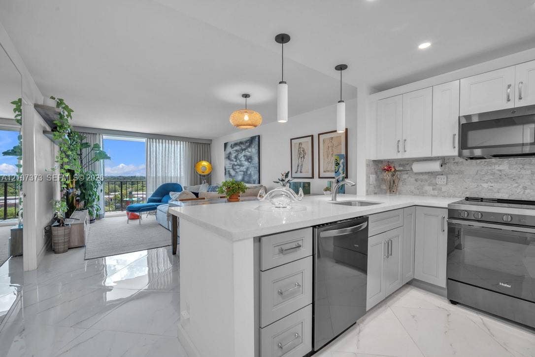 1800 N Andrews Avenue, #9K, Fort Lauderdale, Fort Lauderdale, FL 33311 Kitchen featuring white cabinetry, quartz countertops, stone-finish backsplash, stainless steel appliances, and large-format tile flooring