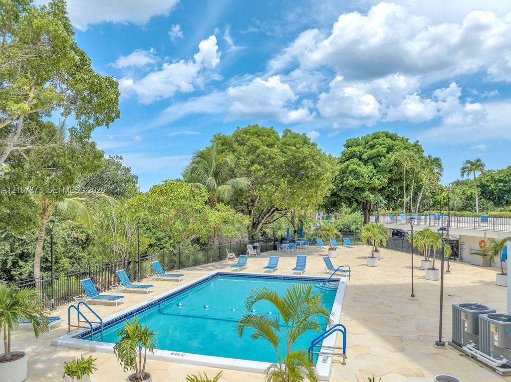 1800 N Andrews Avenue, #9K, Fort Lauderdale, Fort Lauderdale, FL 33311 In-ground swimming pool featuring a flagstone deck, metal safety fencing, built-in handrails, and mature landscaping