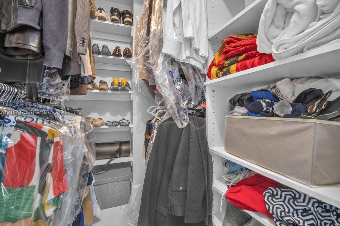 1800 N Andrews Avenue, #9K, Fort Lauderdale, Fort Lauderdale, FL 33311 Walk-in closet featuring floor-to-ceiling white built-in shelving and multi-level hanging rods