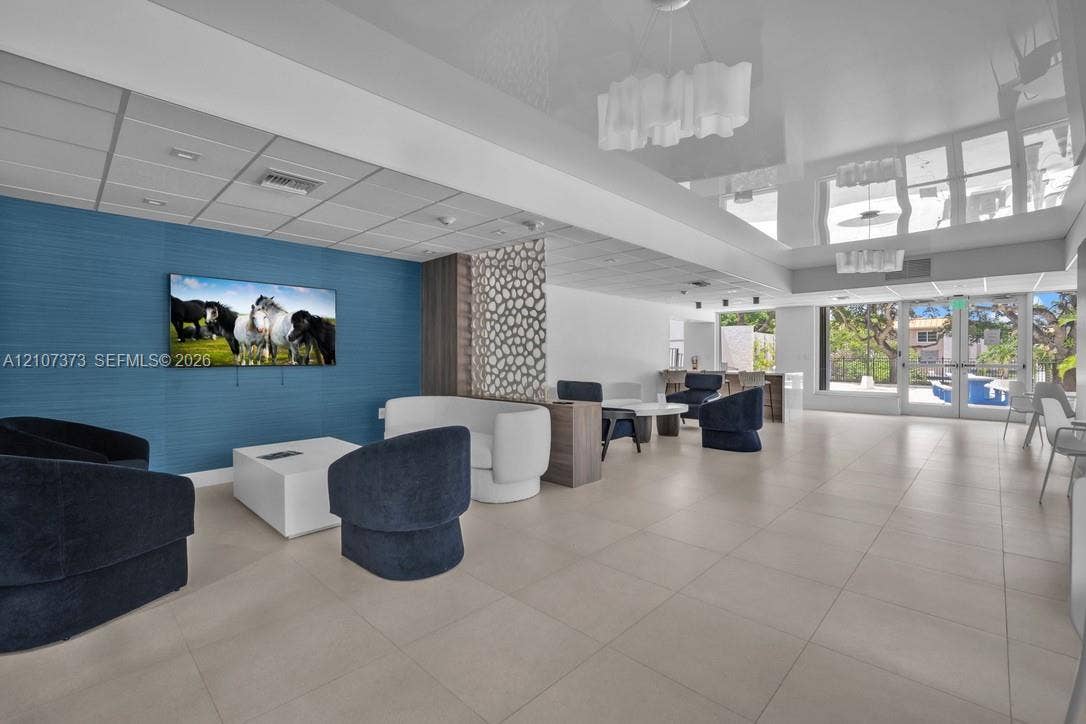 1800 N Andrews Avenue, #9K, Fort Lauderdale, Fort Lauderdale, FL 33311 High-gloss ceiling with modern decorative lighting, large-format tile flooring, textured blue accent wall, and intricate lattice privacy screen