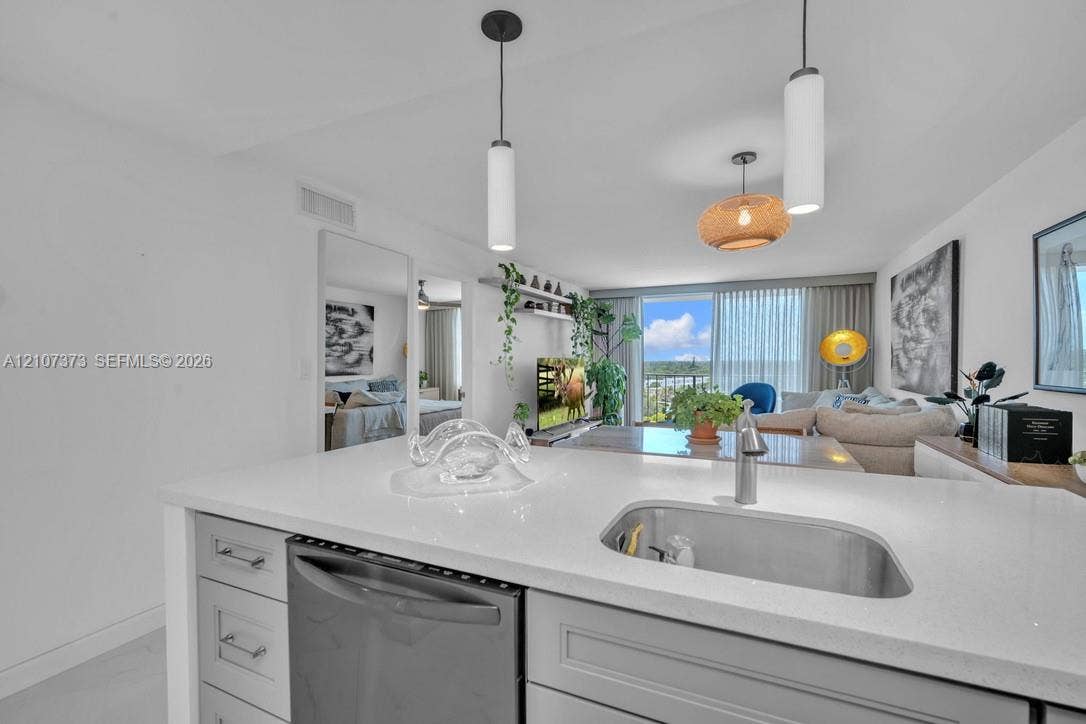 1800 N Andrews Avenue, #9K, Fort Lauderdale, Fort Lauderdale, FL 33311 Kitchen featuring a quartz countertop, undermount stainless steel sink, pull-down chrome faucet, shaker-style cabinetry, and integrated stainless steel dishwasher