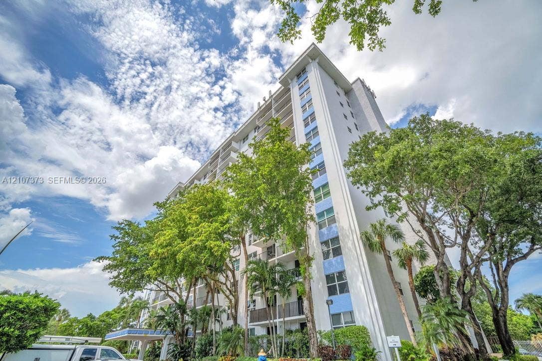 1800 N Andrews Avenue, #9K, Fort Lauderdale, Fort Lauderdale, FL 33311 Mid-rise high-rise residential building featuring a concrete exterior, tiered private balconies, and mature landscaping