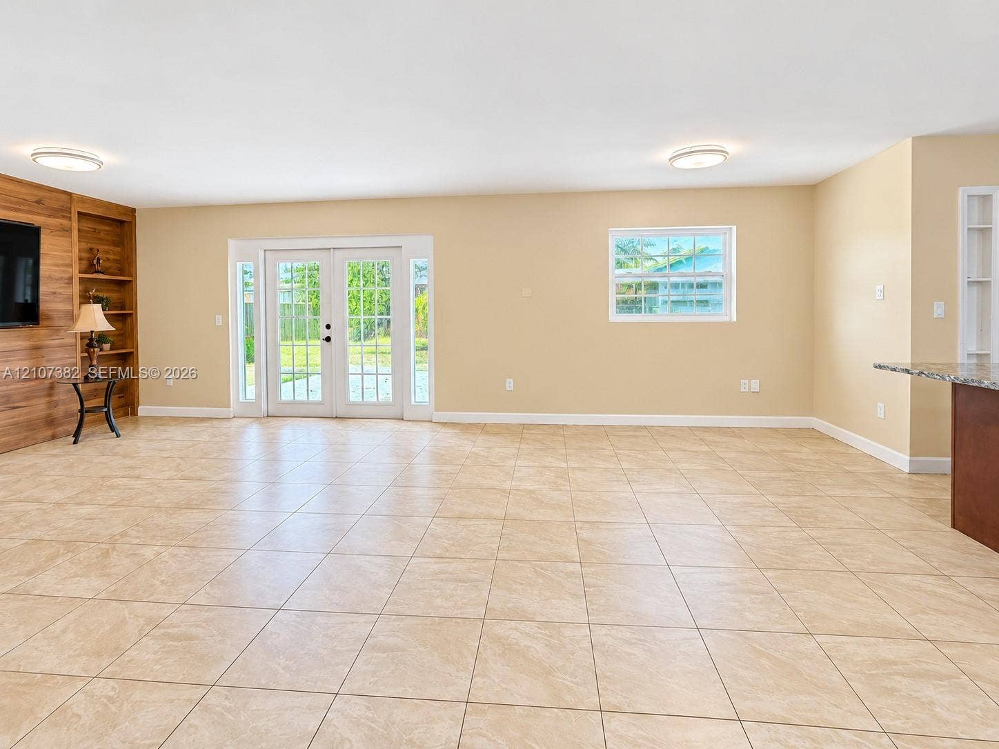 859 Caroline Circle, Palm Beach, FL 33413 Tile flooring, wood-finish wall accent with integrated shelving, double French doors, and recessed ceiling lighting