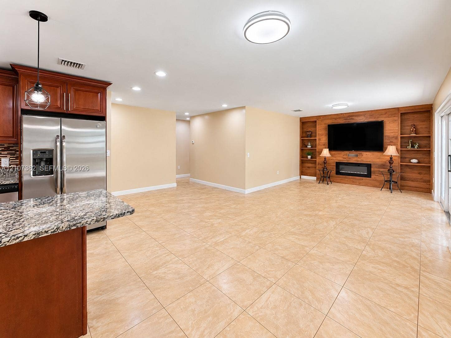 859 Caroline Circle, Palm Beach, FL 33413 Kitchen featuring stone-surface countertops, dark wood cabinetry, and stainless steel refrigerator