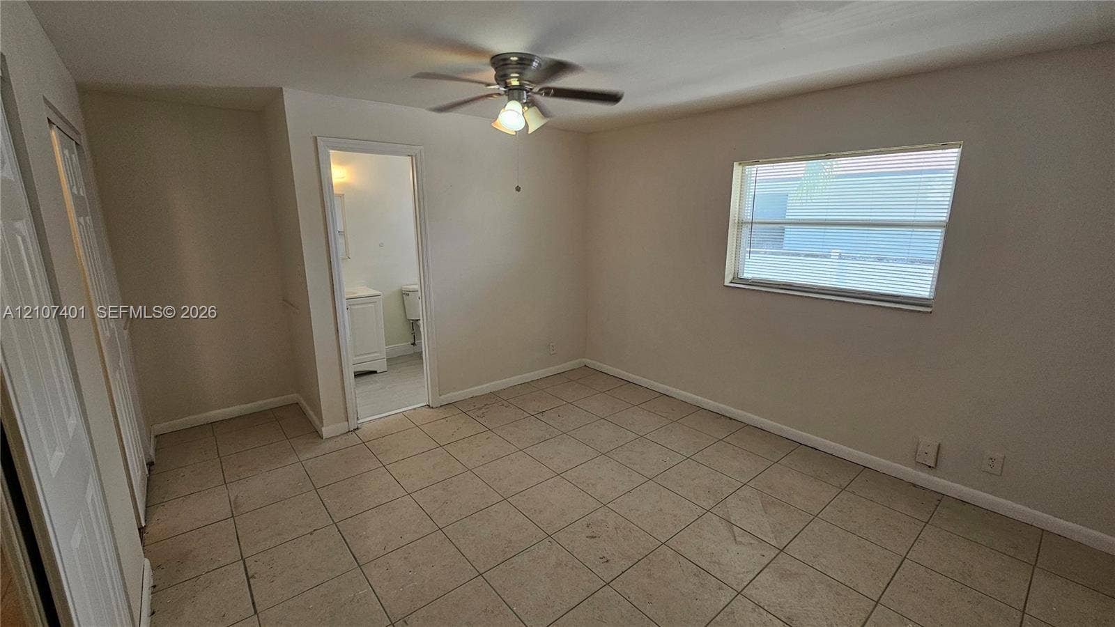 1524 SW 5th Place, #C, Fort Lauderdale, Fort Lauderdale, FL 33312 Interior space featuring neutral wall paint, tile flooring, a multi-blade ceiling fan with integrated lighting, and a single-pane window