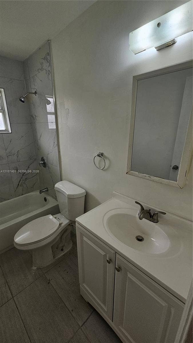 1524 SW 5th Place, #C, Fort Lauderdale, Fort Lauderdale, FL 33312 Bathroom featuring a vanity with a drop-in sink, wall-mounted vanity lighting, a bathtub and shower combination with large-format tile surround, and tile flooring