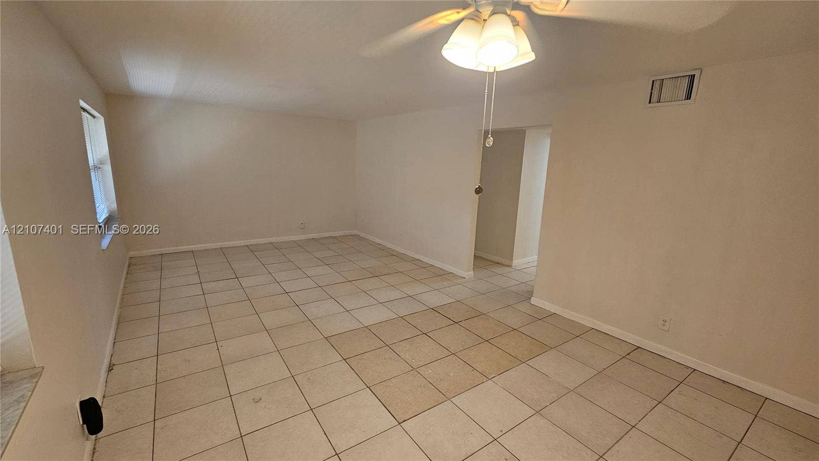 1524 SW 5th Place, #C, Fort Lauderdale, Fort Lauderdale, FL 33312 Interior space featuring light-toned ceramic tile flooring, neutral wall paint, and a ceiling-mounted light fixture with three glass shades