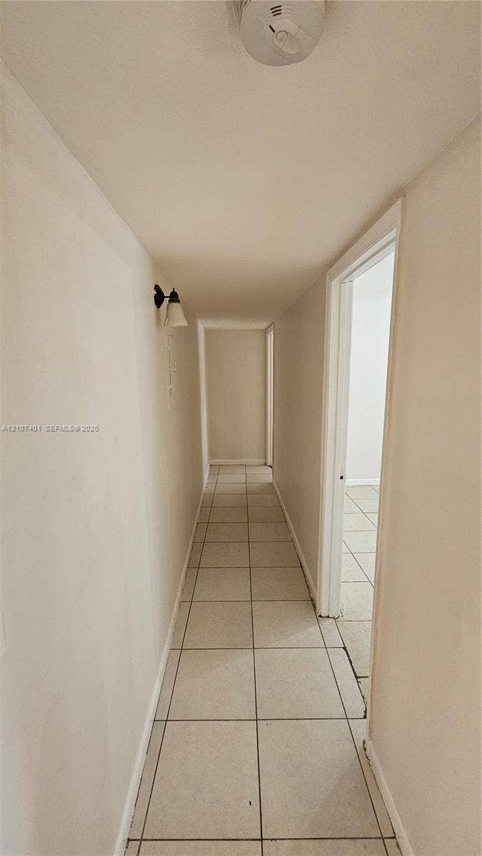 1524 SW 5th Place, #C, Fort Lauderdale, Fort Lauderdale, FL 33312 Hallway featuring ceramic tile flooring, neutral wall finishes, and a wall-mounted light fixture