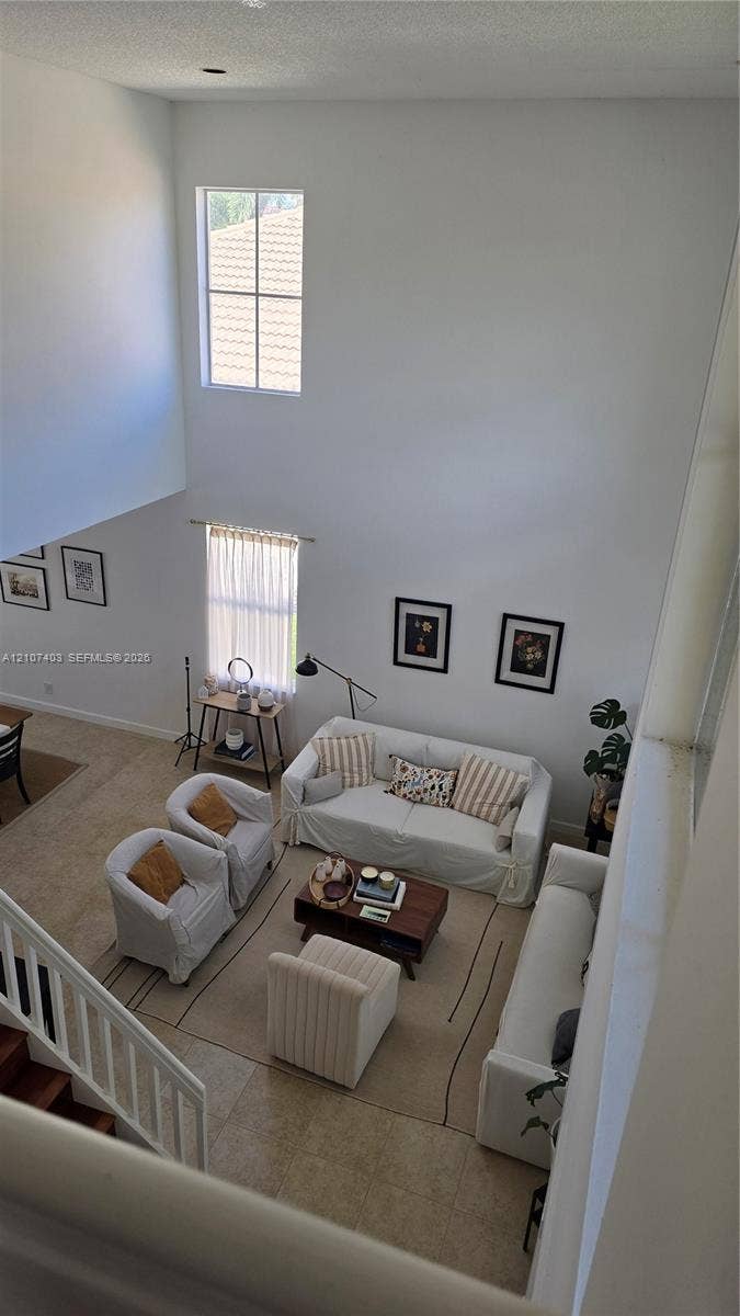 1559 Elm Grove Road, Weston, Weston, FL 33327 High-ceiling interior featuring multi-level windows, neutral tile flooring, and white spindle staircase railing