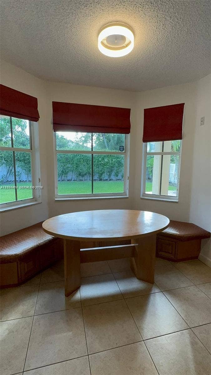 1559 Elm Grove Road, Weston, Weston, FL 33327 Bay window featuring built-in wooden bench seating, neutral floor tile, and a flush-mount overhead light fixture