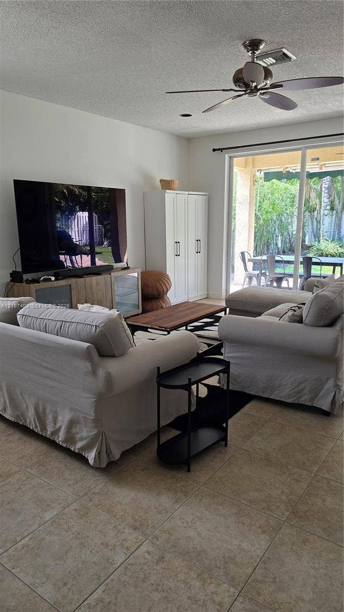 1559 Elm Grove Road, Weston, Weston, FL 33327 Large-format tile flooring, ceiling fan with integrated lighting, and full-height sliding glass door