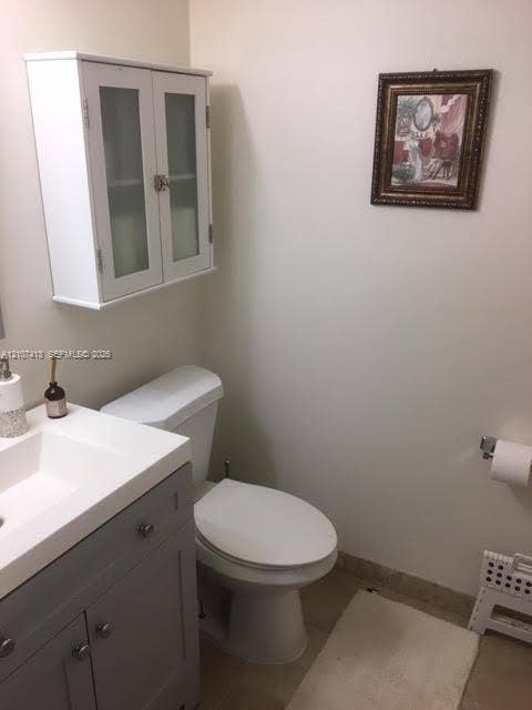 2301 S Ocean Drive, #1606, Hollywood, Hollywood, FL 33019 Grey vanity with a white countertop, wall-mounted white cabinetry with frosted glass doors, and a chrome-finish toilet paper holder