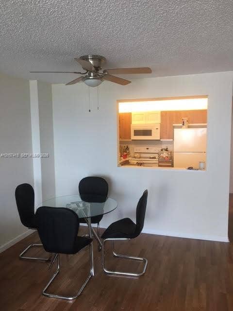 2301 S Ocean Drive, #1606, Hollywood, Hollywood, FL 33019 Wood-finish flooring, ceiling fan with integrated lighting, and built-in serving pass-through window with kitchen cabinetry and appliances