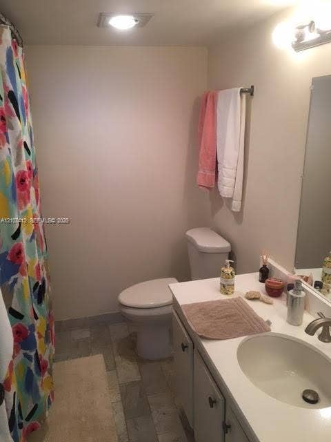 2301 S Ocean Drive, #1606, Hollywood, Hollywood, FL 33019 Bathroom featuring a single-basin vanity with a solid-surface countertop, an undermount sink, multi-tone tile flooring, and a wall-mounted light fixture