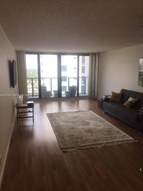 2301 S Ocean Drive, #1606, Hollywood, Hollywood, FL 33019 Living area featuring wood-finish flooring, floor-to-ceiling windows, and a glass-paneled balcony