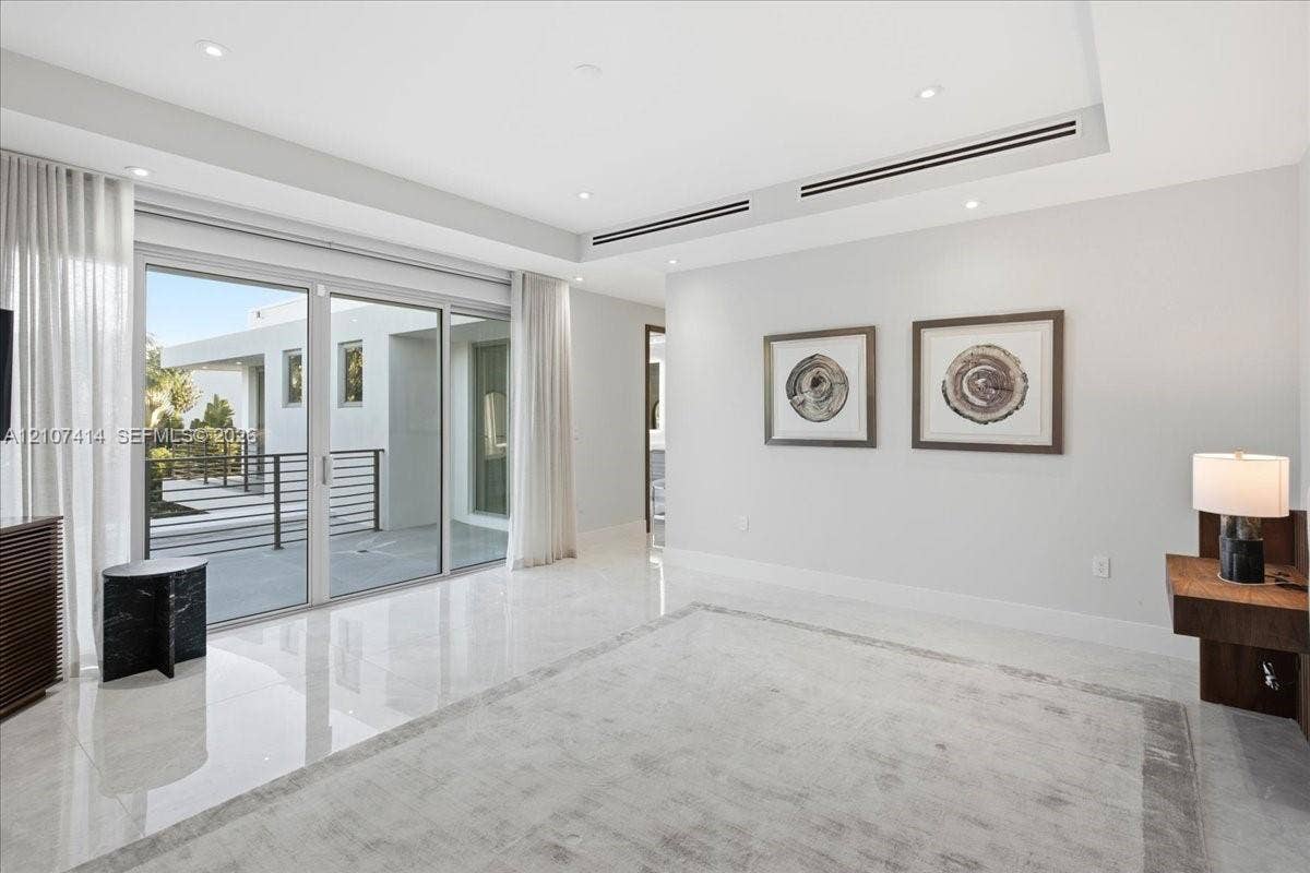 Interior space featuring polished stone flooring, recessed lighting, linear ceiling vents, and large-format sliding glass doors with access to an exterior terrace
