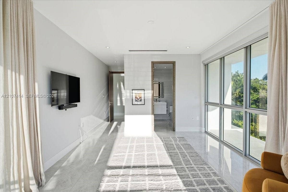 Expansive room featuring floor-to-ceiling windows, polished stone flooring, recessed ceiling lighting, and neutral wall tones