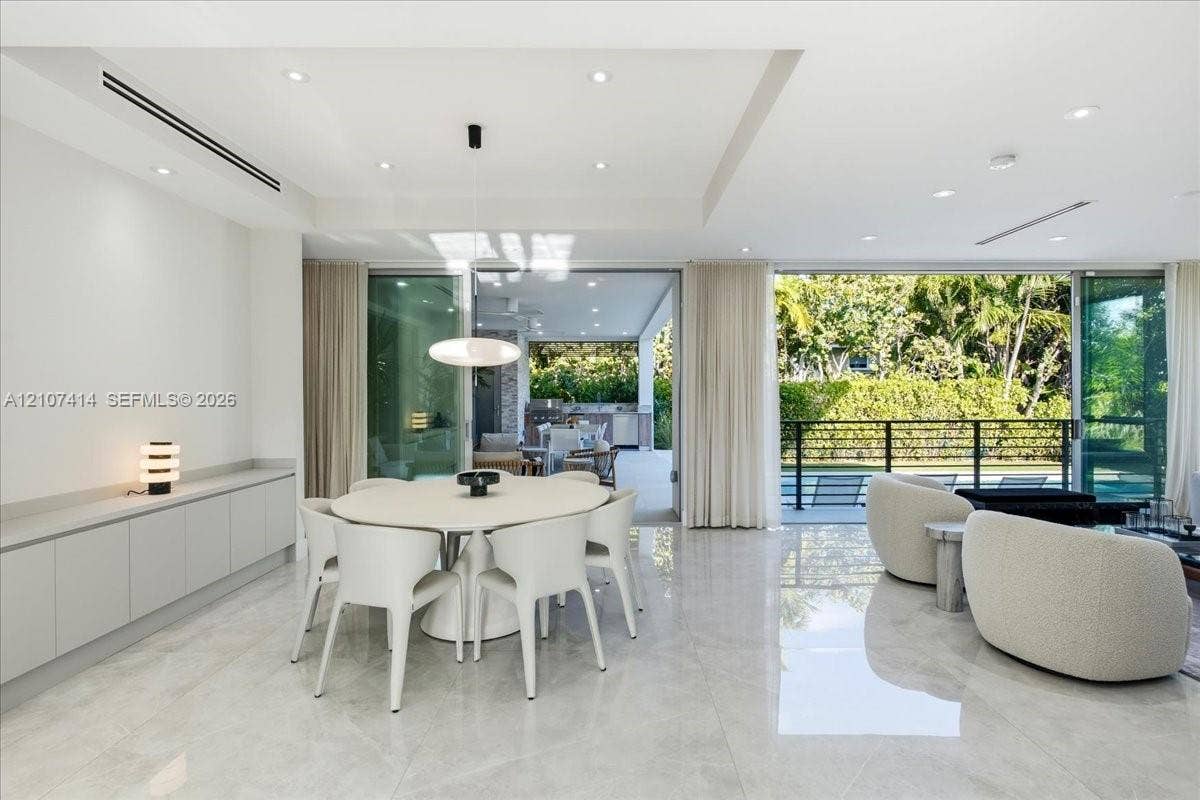 Large-format polished tile flooring, recessed ceiling lighting, built-in floor-to-ceiling cabinetry, and expansive multi-panel sliding glass doors
