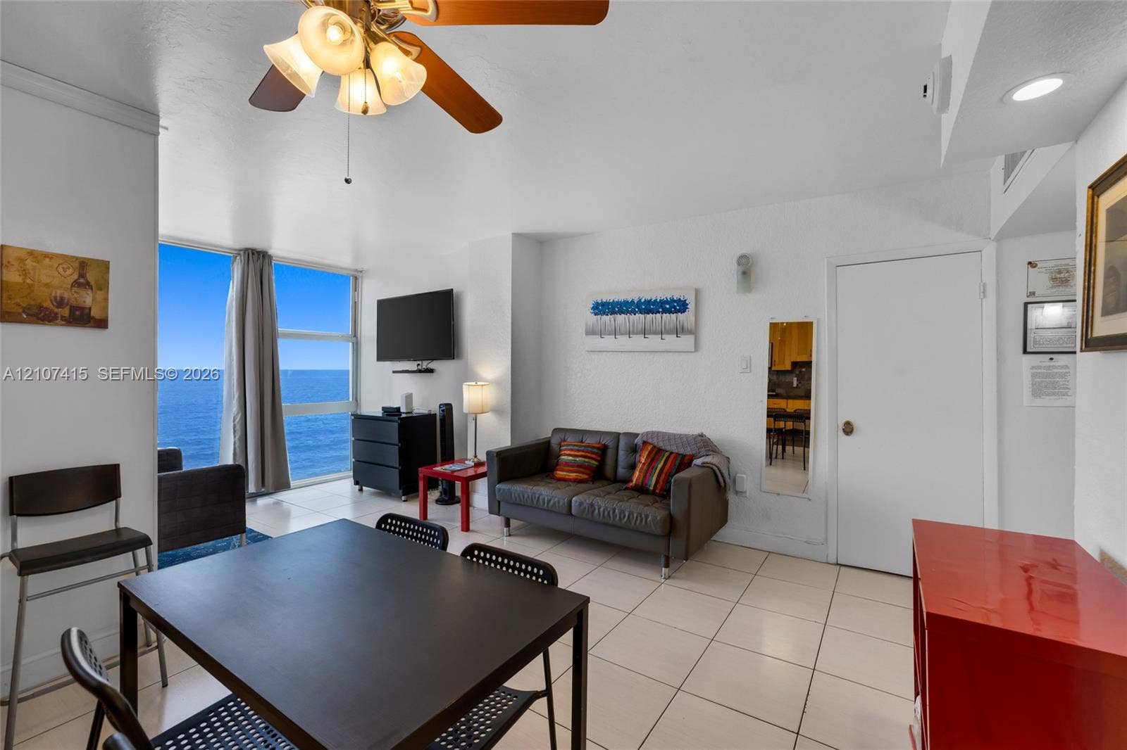Floor-to-ceiling windows, tile flooring, and ceiling fan with integrated lighting