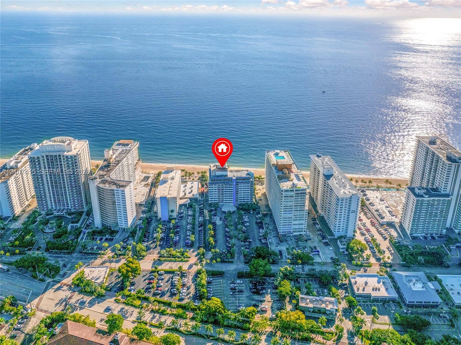 Aerial coastal location featuring direct ocean frontage, proximity to sand, and multi-story structural architecture