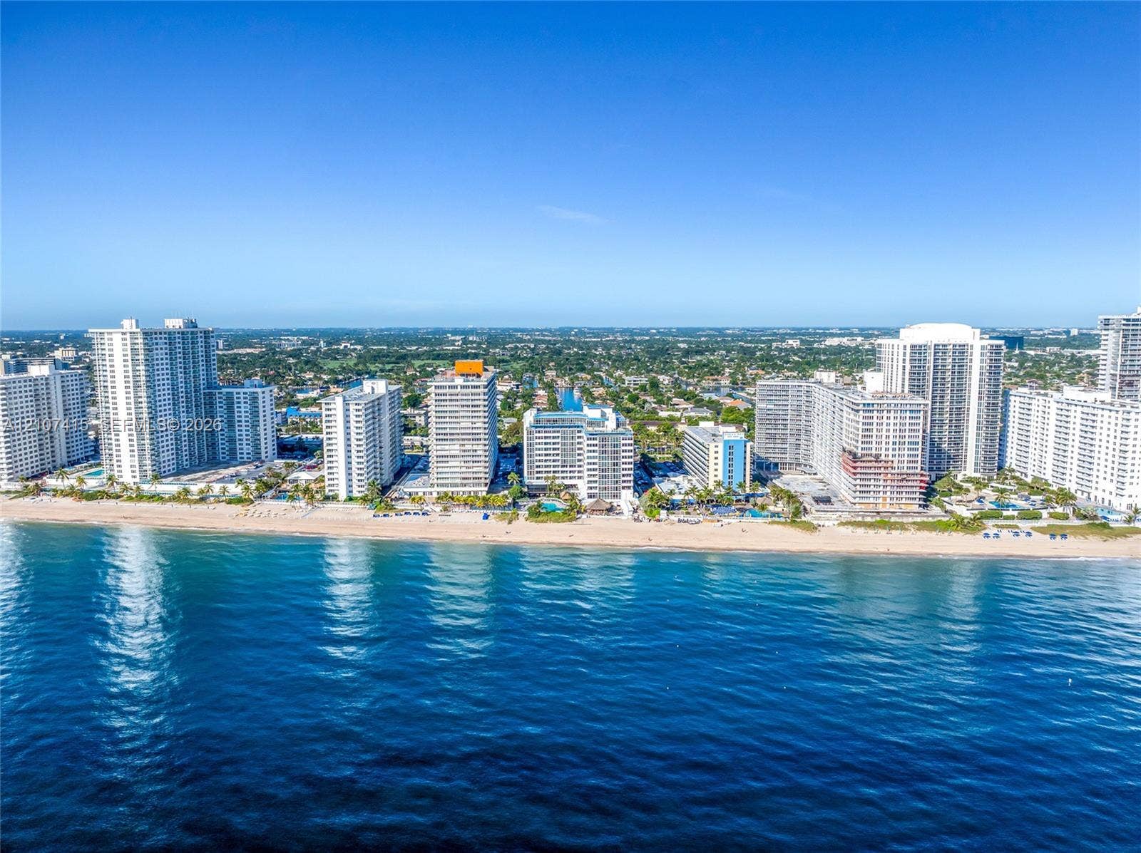 Coastal cityscape featuring high-rise architecture, direct shoreline access, and expansive ocean frontage