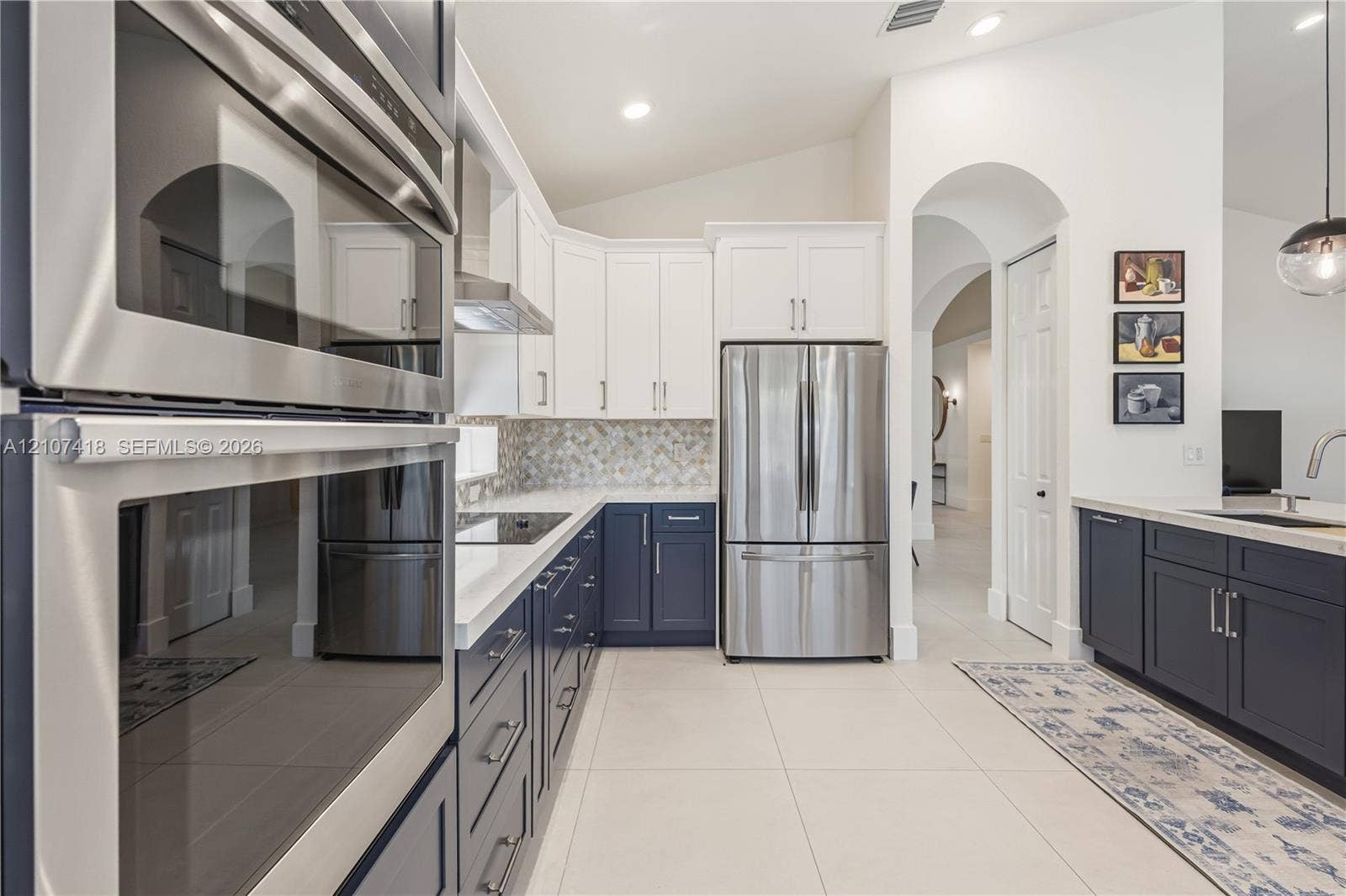 19305 Skyridge Circle, #n/a, Boca Raton, Boca Raton, FL 33498 Kitchen featuring dual-tone cabinetry, stainless steel appliances, quartz countertops, mosaic tile backsplash, and large-format tile flooring