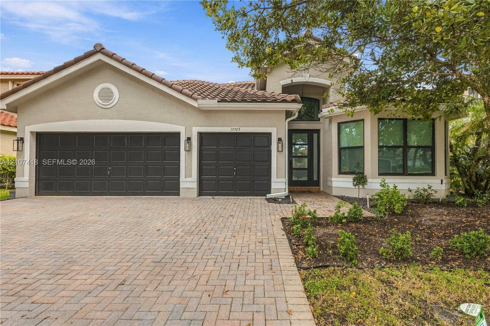 19305 Skyridge Circle, #n/a, Boca Raton, Boca Raton, FL 33498 Stucco exterior with a tiled roof, paver driveway, three-car garage, and multi-pane windows