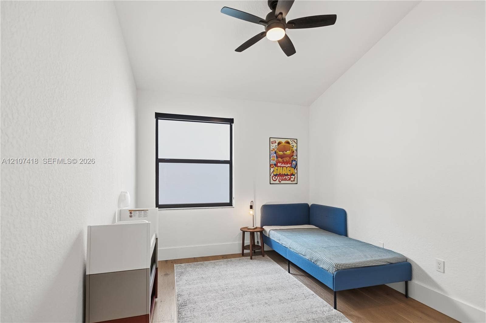 19305 Skyridge Circle, #n/a, Boca Raton, Boca Raton, FL 33498 Room featuring wood-finish flooring, a matte black multi-blade ceiling fan with integrated lighting, and a window with a matte black frame