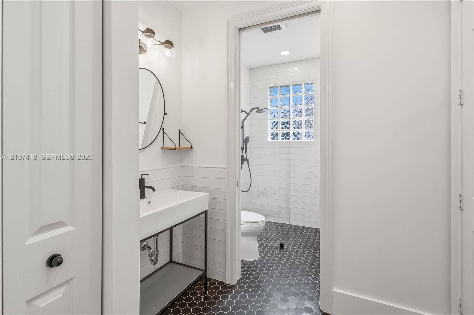 19305 Skyridge Circle, #n/a, Boca Raton, Boca Raton, FL 33498 Bathroom featuring a console-style vanity with a rectangular sink, matte black plumbing fixtures, white subway tile wall treatments, and hexagonal floor tiling