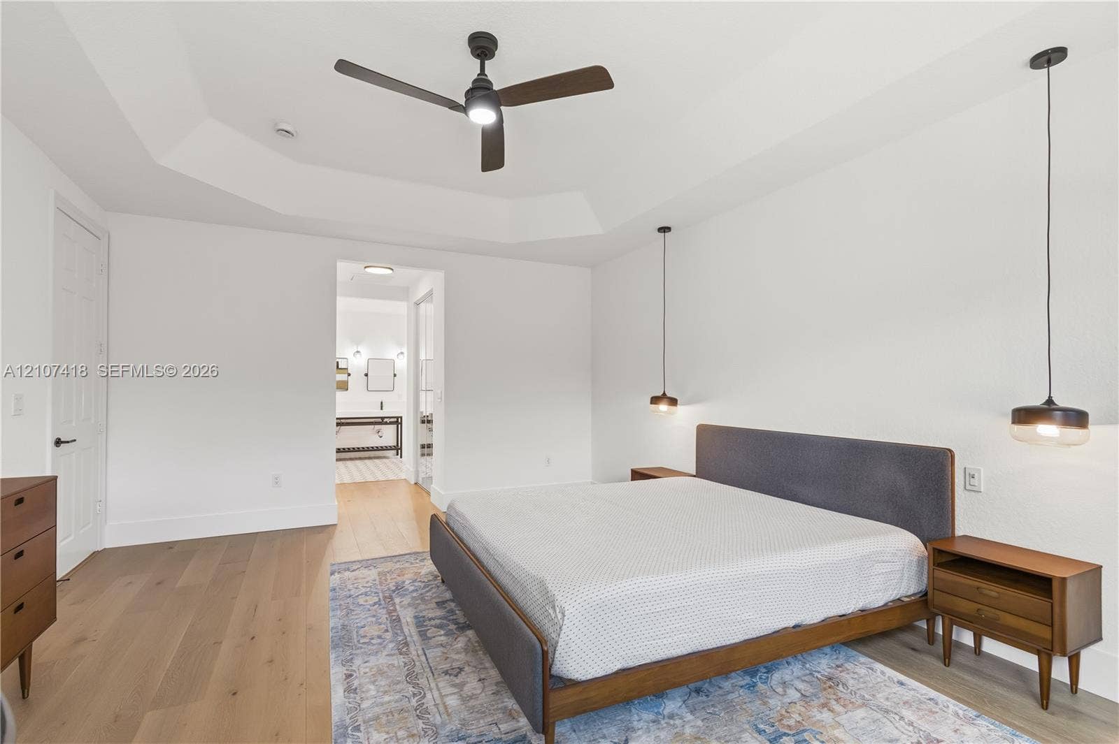 19305 Skyridge Circle, #n/a, Boca Raton, Boca Raton, FL 33498 Tray ceiling, wood-finish flooring, matte black ceiling fan, and dual suspended pendant light fixtures