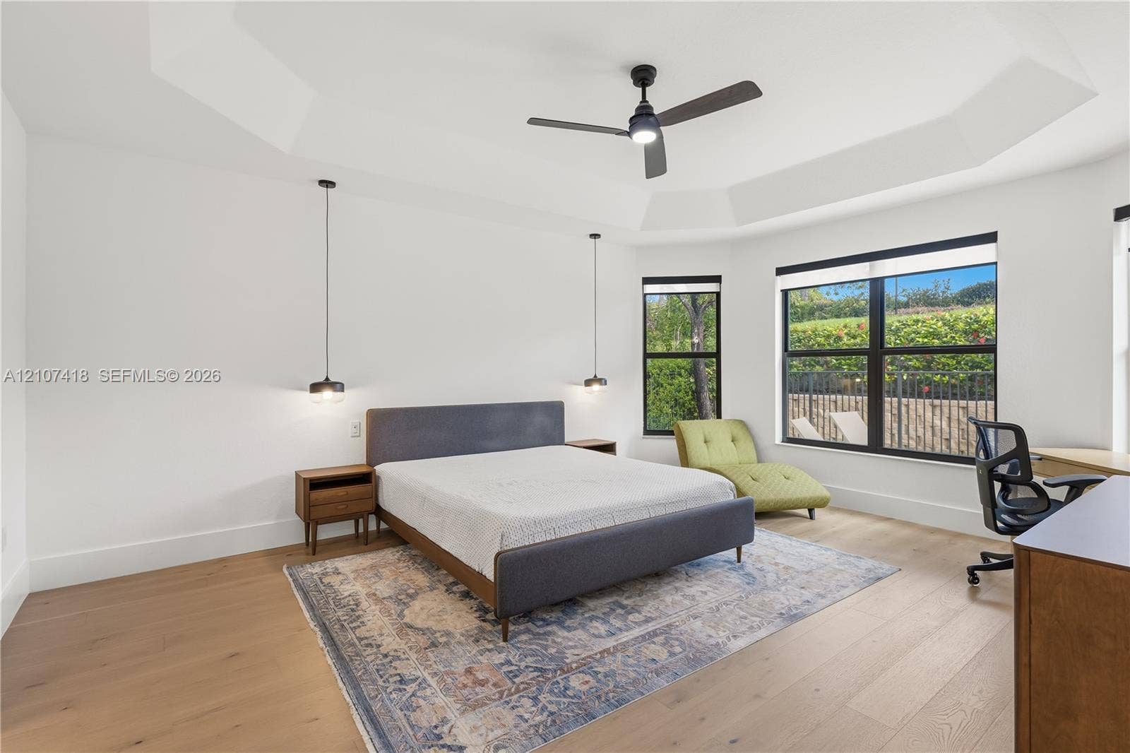 19305 Skyridge Circle, #n/a, Boca Raton, Boca Raton, FL 33498 Tray ceiling, wood-finish flooring, matte black ceiling fan, and black-framed windows