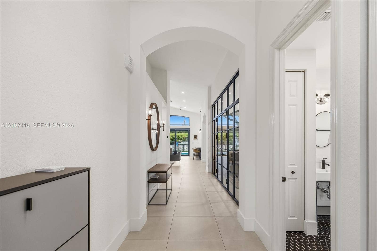 19305 Skyridge Circle, #n/a, Boca Raton, Boca Raton, FL 33498 Entryway featuring a high arched passage, large-format tile flooring, recessed ceiling lighting, and a floor-to-ceiling metal-framed glass partition