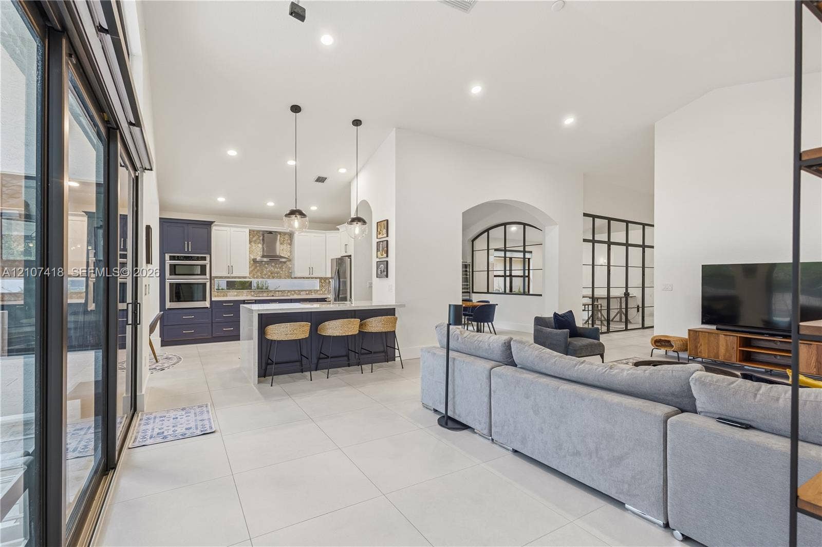 19305 Skyridge Circle, #n/a, Boca Raton, Boca Raton, FL 33498 Open-concept kitchen featuring two-toned cabinetry, a large central island, recessed lighting, glass-paneled interior partitions, and porcelain tile flooring