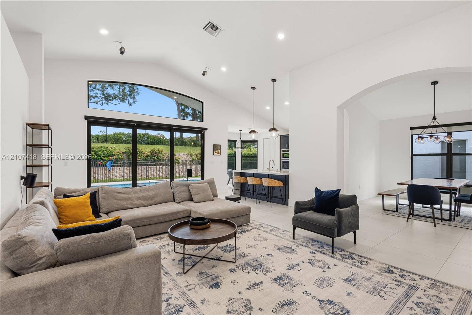 19305 Skyridge Circle, #n/a, Boca Raton, Boca Raton, FL 33498 Vaulted ceilings, expansive windows with exterior transom, large-format tile flooring, recessed lighting, and kitchen island with pendant fixtures
