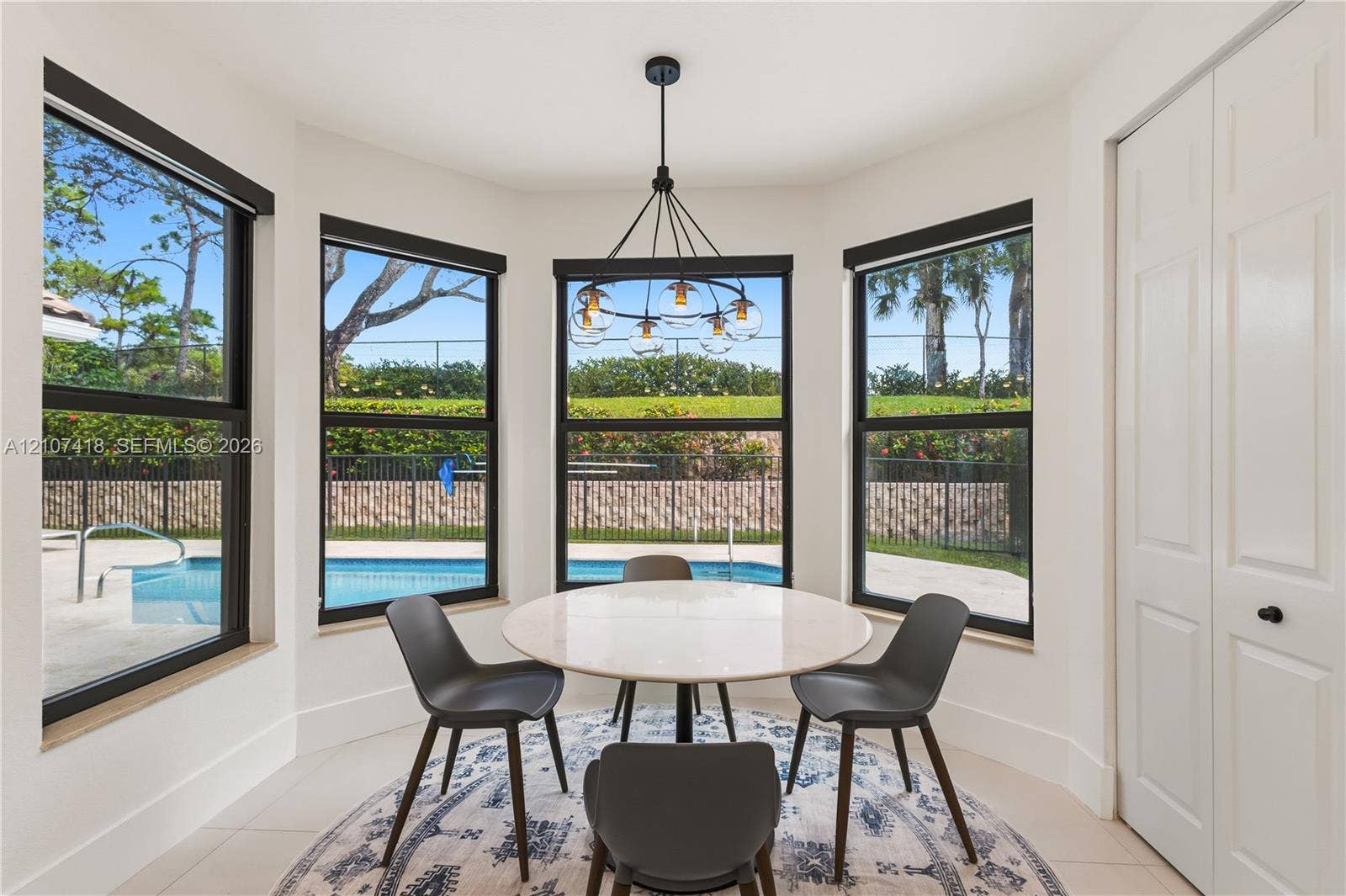 19305 Skyridge Circle, #n/a, Boca Raton, Boca Raton, FL 33498 Bay window featuring floor-to-ceiling windows with black frames, tile flooring, and a multi-arm modern chandelier