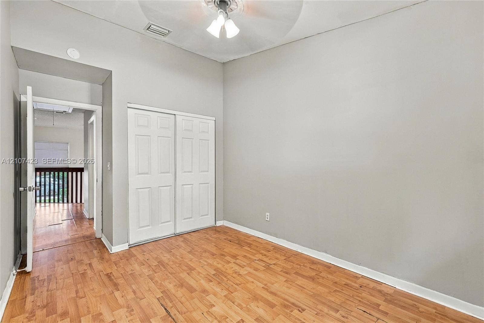 650 NE 195th Street, Miami, FL 33179 Room featuring wood-finish flooring, high ceilings, ceiling-mounted light fixture, and double-door closet