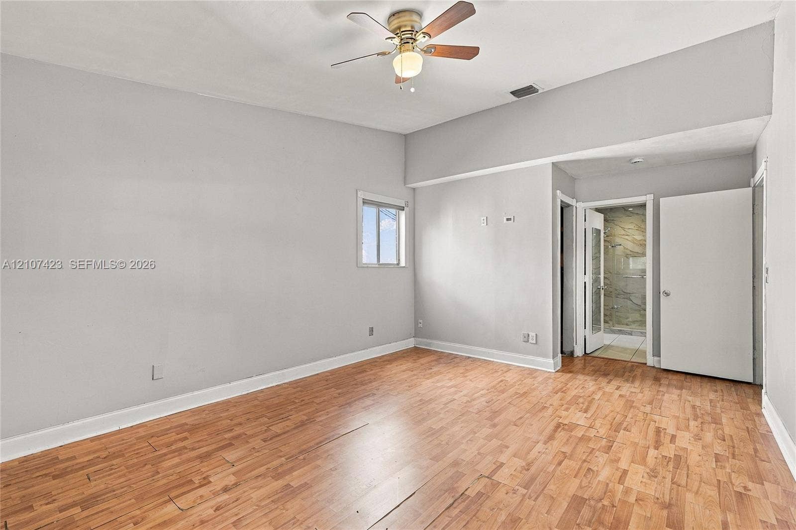 650 NE 195th Street, Miami, FL 33179 Room featuring wood-finish flooring, vaulted ceiling, and a central ceiling fan with integrated lighting