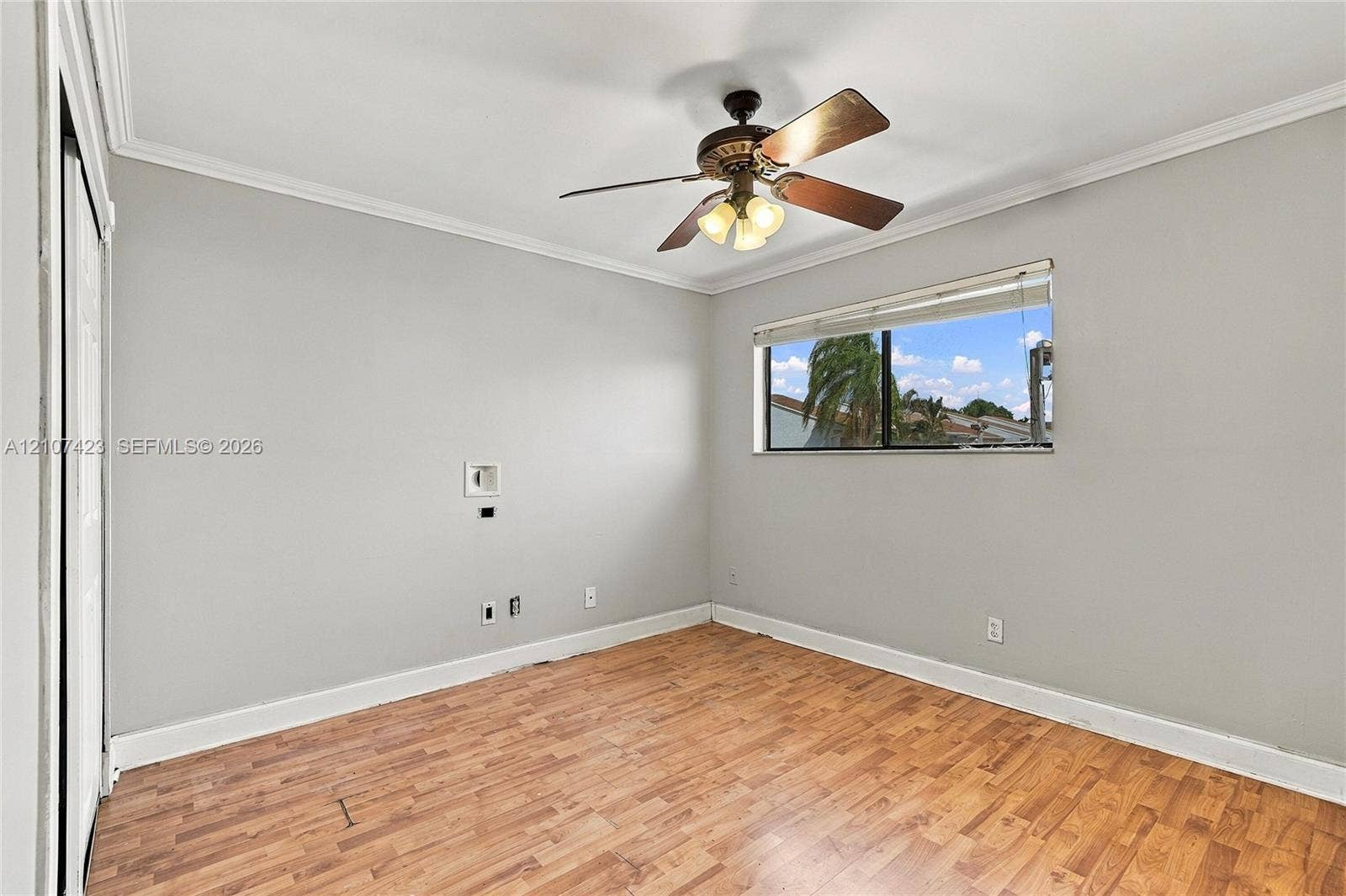 650 NE 195th Street, Miami, FL 33179 Wood-finish flooring, neutral wall tones, multi-light ceiling fan, and horizontal window blinds
