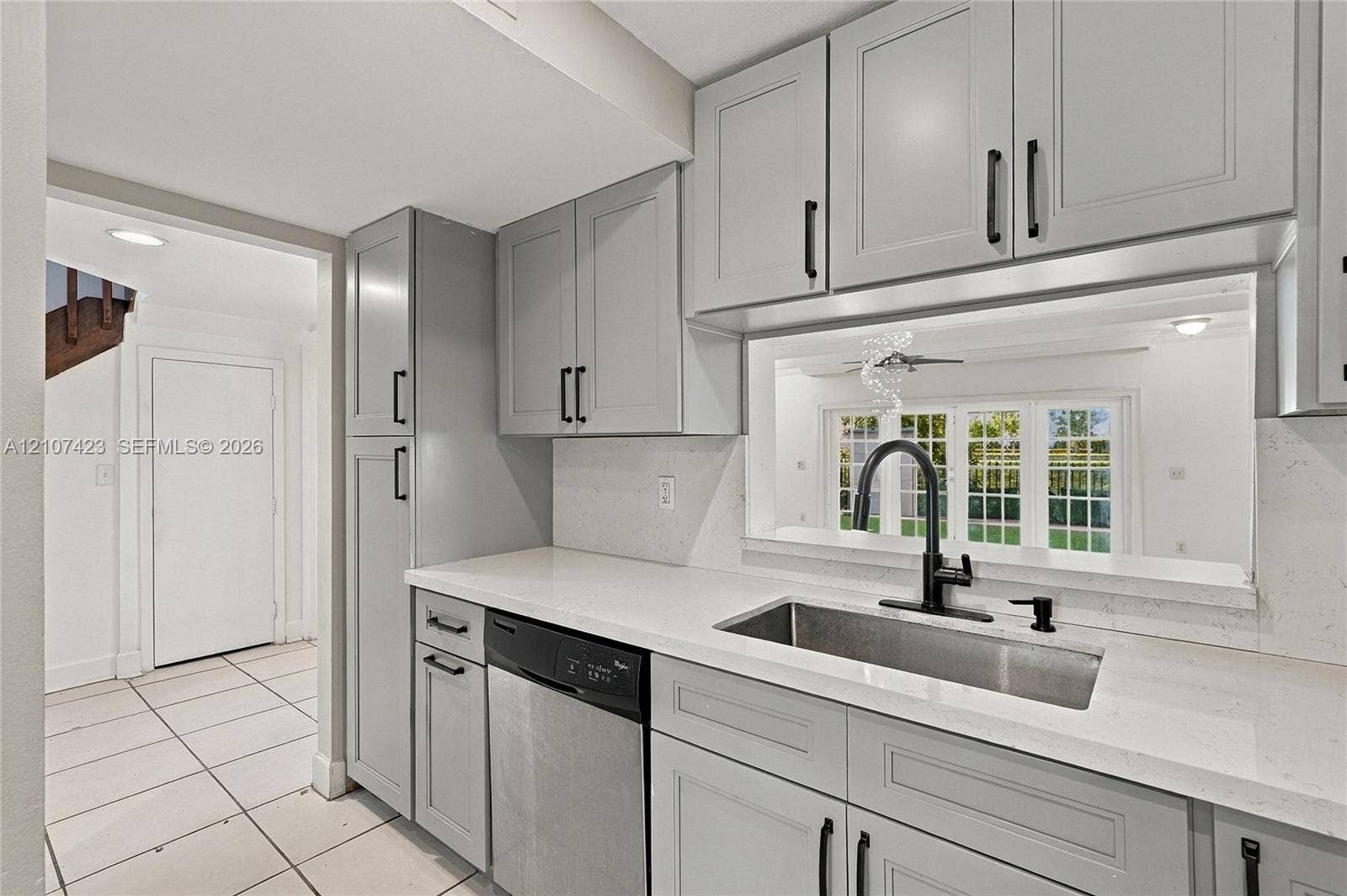 650 NE 195th Street, Miami, FL 33179 Kitchen featuring grey Shaker-style cabinetry, quartz countertops, stainless steel undermount sink with matte black faucet, and built-in dishwasher