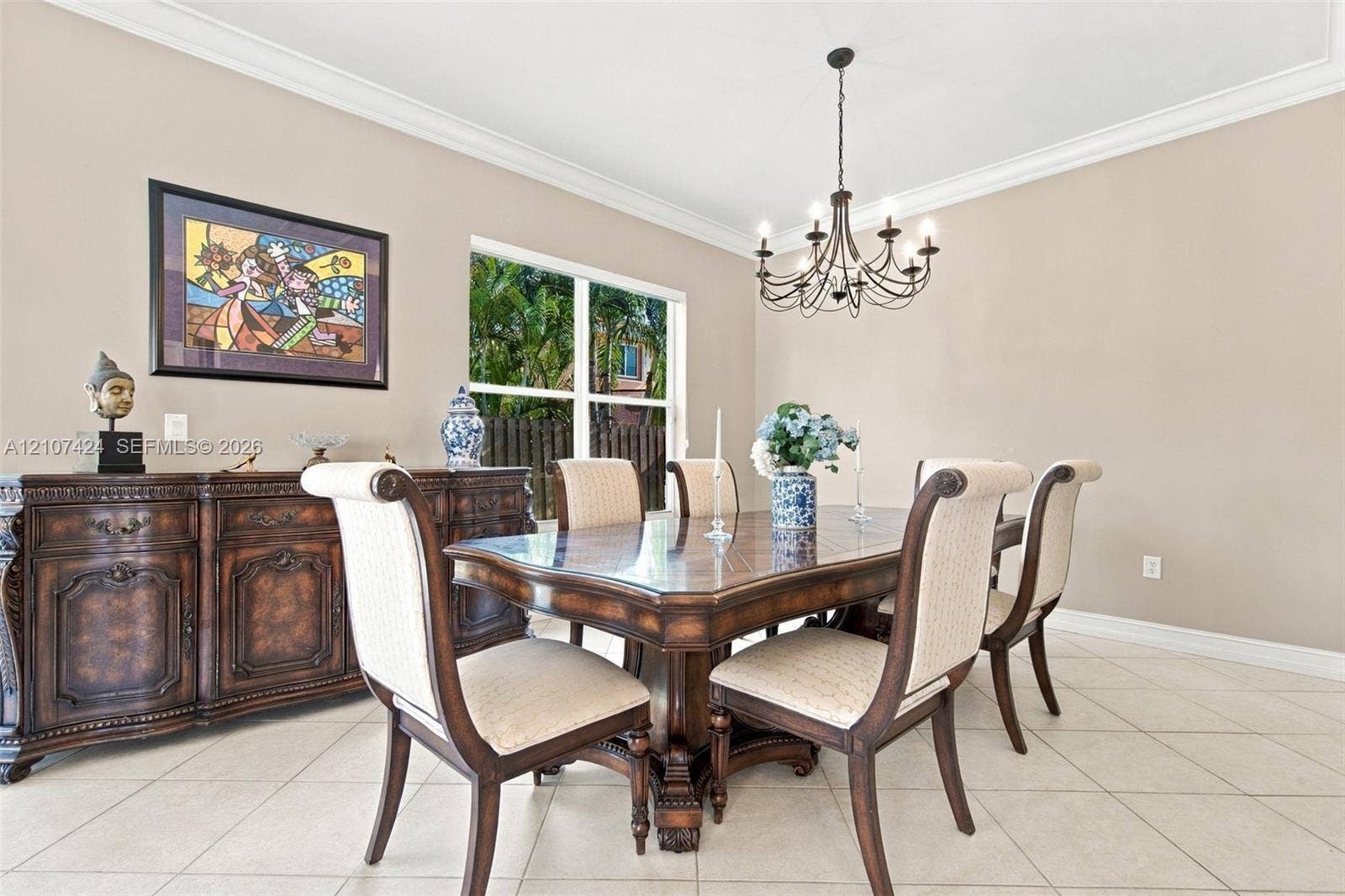14702 Vista Luna Drive, Davie, FL 33325 Dining area featuring neutral wall paint, tile flooring, crown molding, and an eight-light chandelier