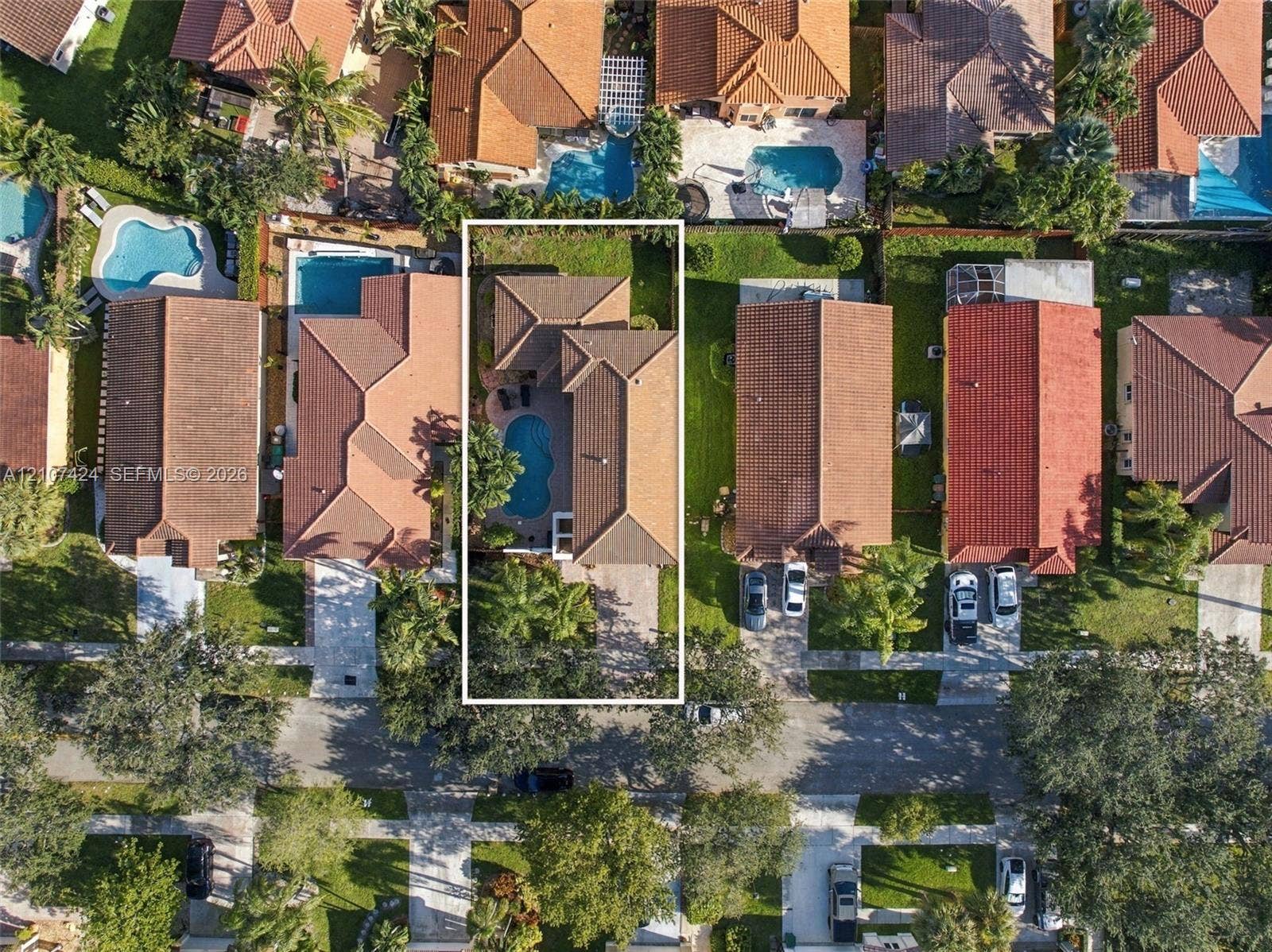14702 Vista Luna Drive, Davie, FL 33325 Aerial view of property featuring a tile roof, private swimming pool, paved driveway, and mature landscaping