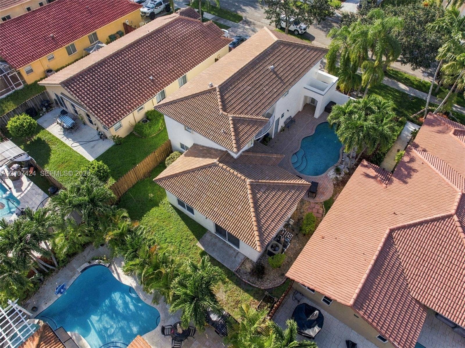 14702 Vista Luna Drive, Davie, FL 33325 Aerial perspective of a two-story residence featuring a tile roof, an in-ground swimming pool, and stone paver decking