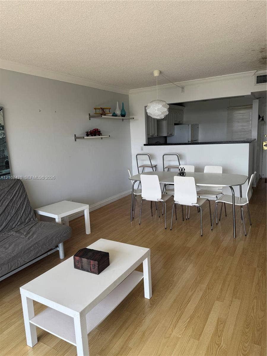 3475 N Country Club Drive, #704, Aventura, Aventura, FL 33180 Wood-finish flooring, wall-mounted display shelving, modern pendant lighting, and pass-through counter