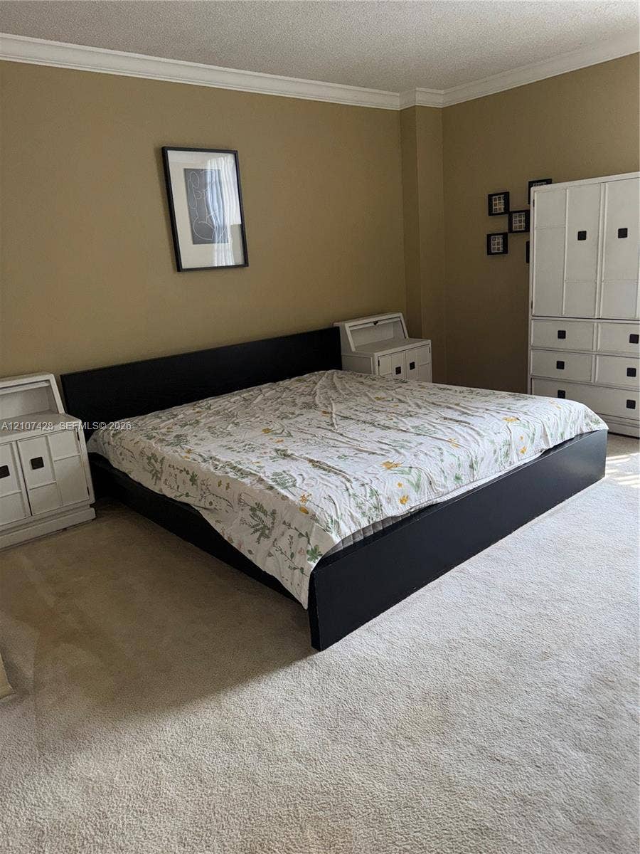 3475 N Country Club Drive, #704, Aventura, Aventura, FL 33180 Neutral-toned interior space featuring crown molding and wall-to-wall carpeting